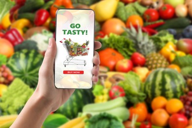 Image of Food delivery. Man using mobile phone app to order grocery online, closeup