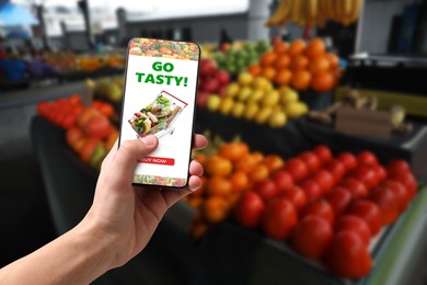 Image of Food delivery. Man using mobile phone app to order grocery online, closeup