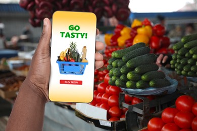 Image of Food delivery. Man using mobile phone app to order grocery online, closeup
