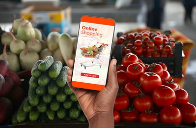 Image of Food delivery. Man using mobile phone app to order grocery online, closeup