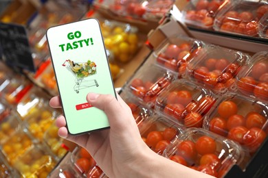 Image of Food delivery. Man using mobile phone app to order grocery online, closeup