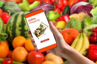 Image of Food delivery. Man using mobile phone app to order grocery online, closeup