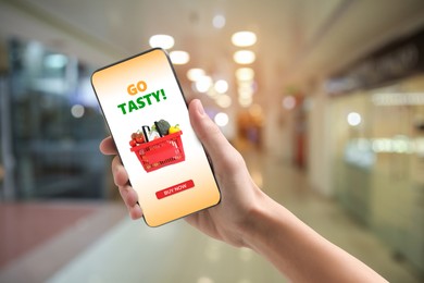 Image of Food delivery. Man using mobile phone app to order grocery online, closeup
