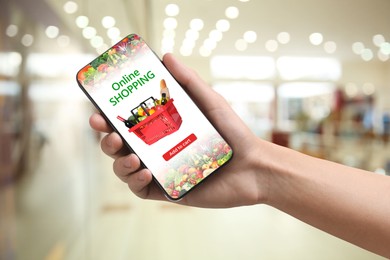 Image of Food delivery. Man using mobile phone app to order grocery online, closeup