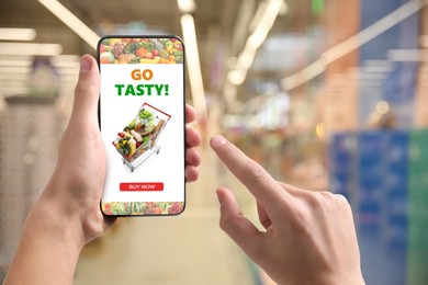 Image of Food delivery. Man using mobile phone app to order grocery online, closeup