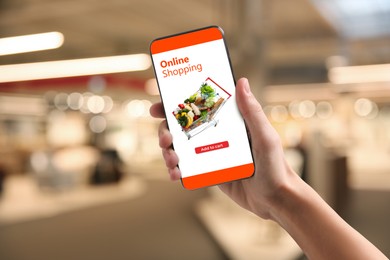 Image of Food delivery. Man using mobile phone app to order grocery online, closeup