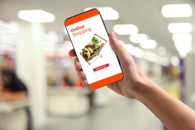 Image of Food delivery. Man using mobile phone app to order grocery online, closeup