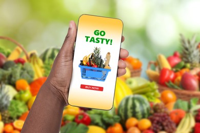 Image of Food delivery. Man using mobile phone app to order grocery online, closeup