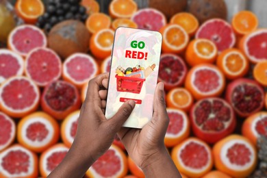 Image of Food delivery. Man using mobile phone app to order grocery online, closeup