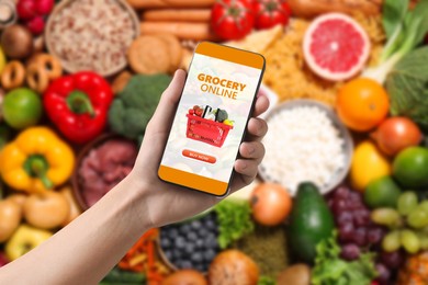 Image of Food delivery. Man using mobile phone app to order grocery online, closeup