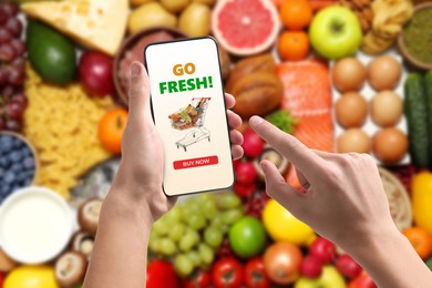 Image of Food delivery. Man using mobile phone app to order grocery online, closeup