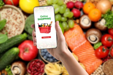 Image of Food delivery. Man using mobile phone app to order grocery online, closeup