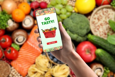 Image of Food delivery. Man using mobile phone app to order grocery online, closeup