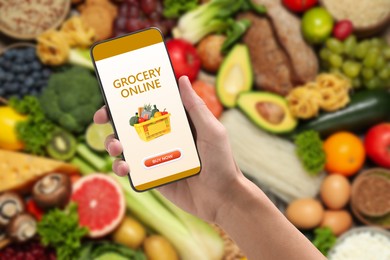 Image of Food delivery. Man using mobile phone app to order grocery online, closeup
