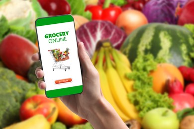 Image of Food delivery. Man using mobile phone app to order grocery online, closeup