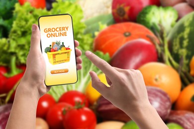 Image of Food delivery. Man using mobile phone app to order grocery online, closeup