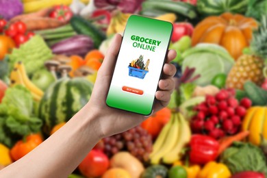 Image of Food delivery. Man using mobile phone app to order grocery online, closeup