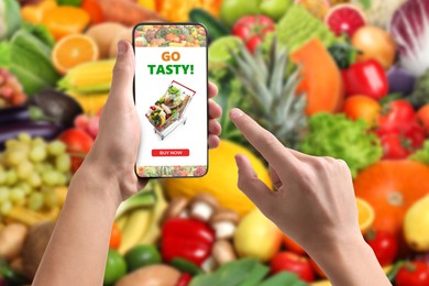 Image of Food delivery. Man using mobile phone app to order grocery online, closeup