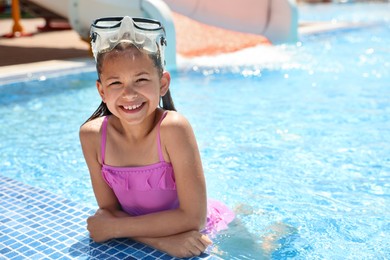 Photo of Little girl wearing diving mask in swimming pool. Summer vacation