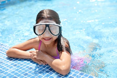 Photo of Little girl wearing diving mask in swimming pool. Summer vacation