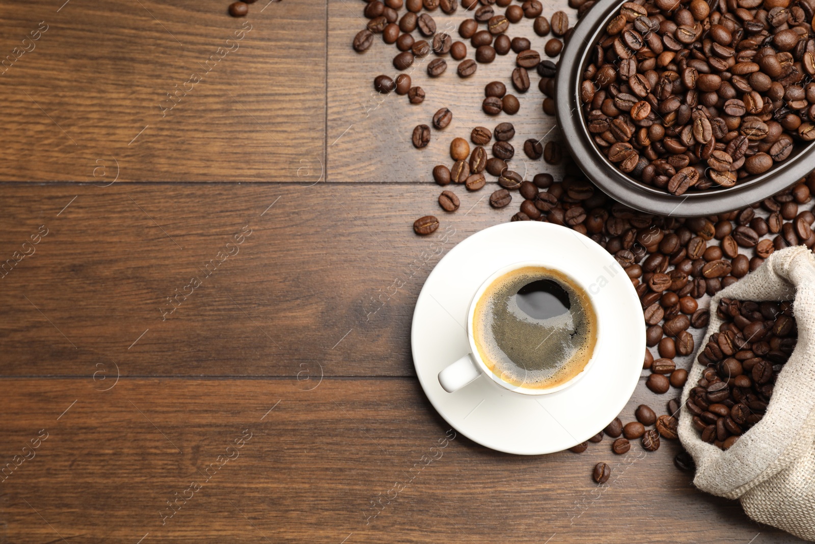 Aromatic coffee in cup and beans on wooden table, flat lay. Space for text Photo of Aromatic coffee in cup and beans on wooden table, flat lay. Space for text