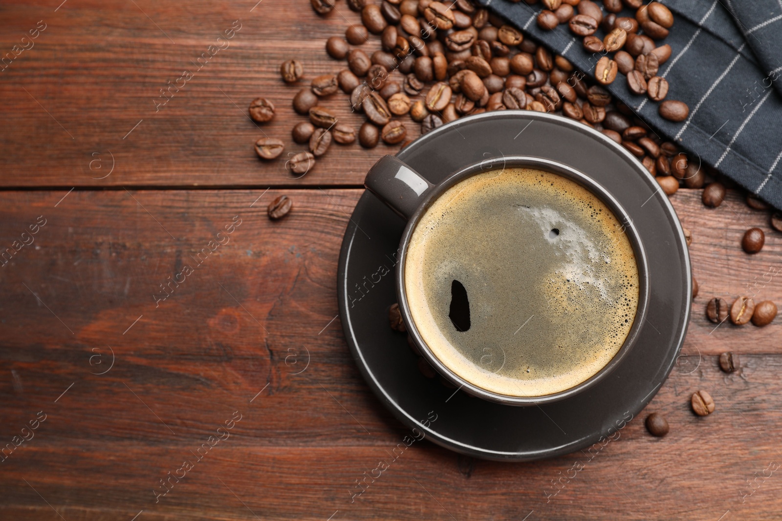 Aromatic coffee in cup and beans on wooden table, flat lay. Space for text Photo of Aromatic coffee in cup and beans on wooden table, flat lay. Space for text