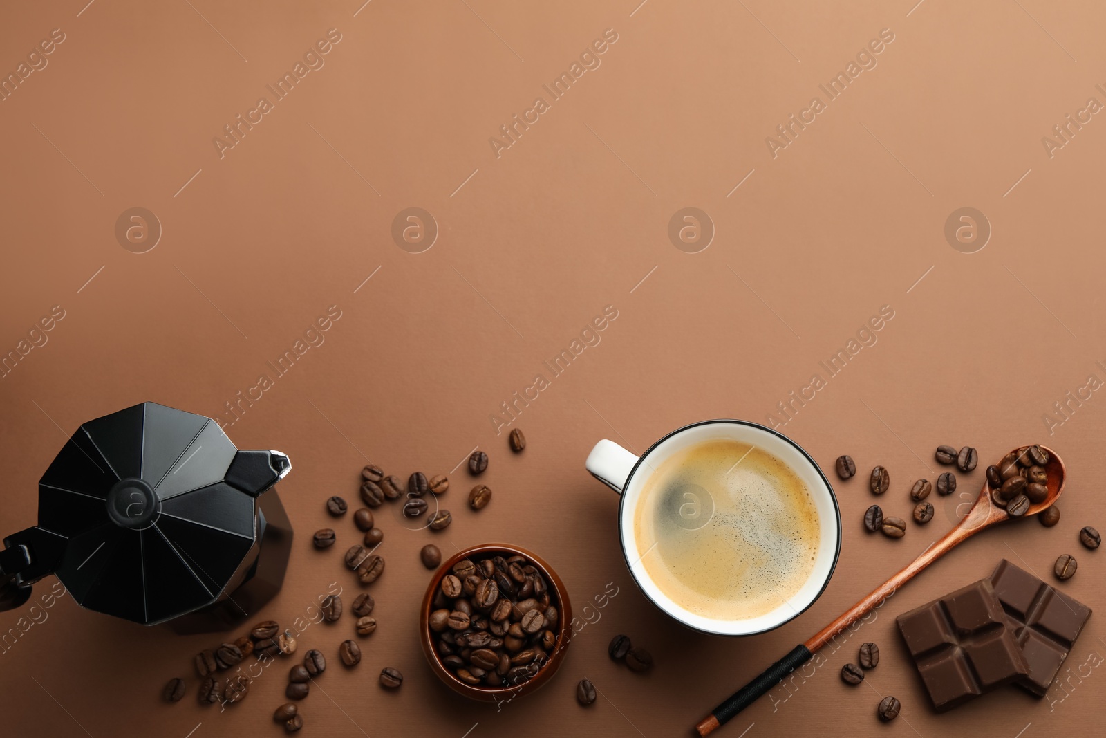 Photo of Aromatic coffee in cup, beans, moka pot and pieces of chocolate on brown background, flat lay. Space for text