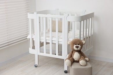 Photo of Baby's room with crib and cute teddy bear. Interior design