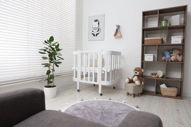 Photo of Baby's room with crib and toys. Interior design