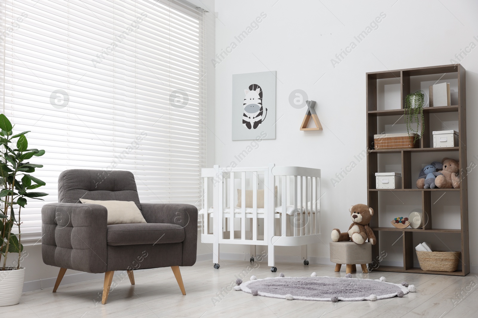 Baby's room with crib and armchair. Interior design Photo of Baby's room with crib and armchair. Interior design