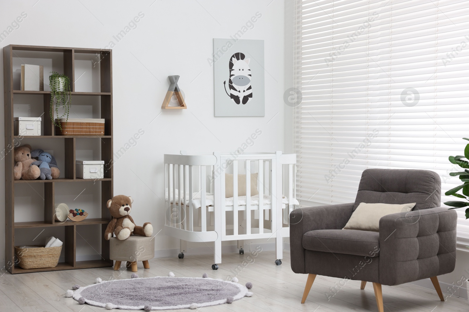 Baby's room with crib and armchair. Interior design Photo of Baby's room with crib and armchair. Interior design