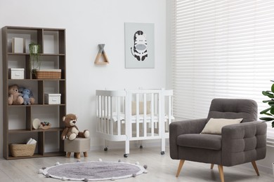Photo of Baby's room with crib and armchair. Interior design