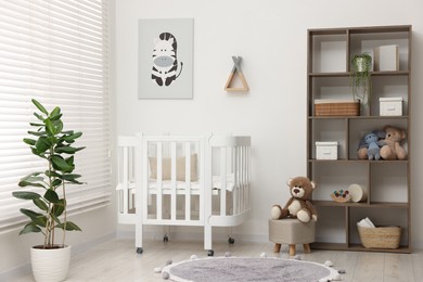 Photo of Baby's room with crib and toys. Interior design