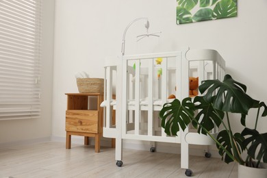 Photo of Baby's room with crib and toys. Interior design