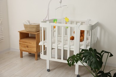 Photo of Baby's room with crib and toys. Interior design