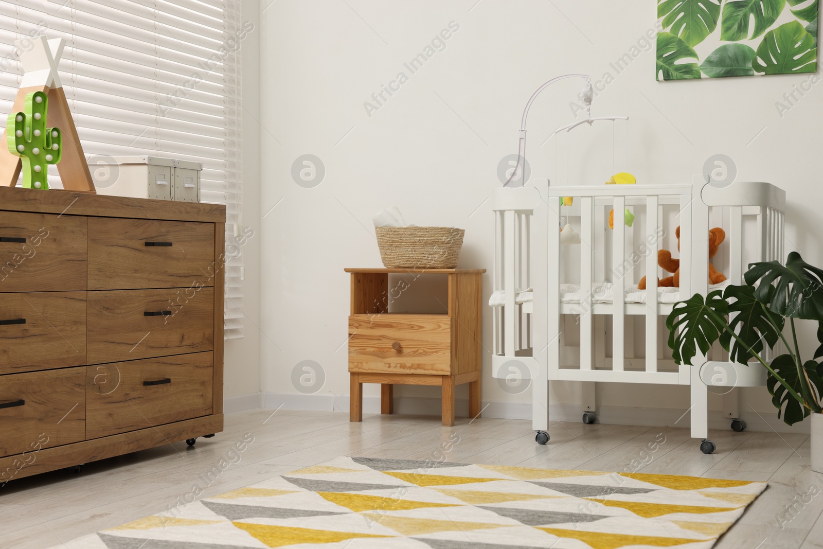 Photo of Baby's room with crib and toys. Interior design
