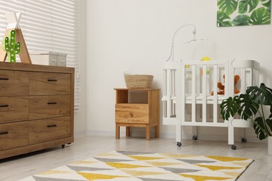 Photo of Baby's room with crib and toys. Interior design