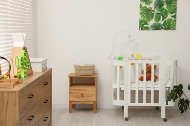 Photo of Baby's room with crib and toys. Interior design