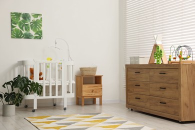 Photo of Baby's room with crib and toys. Interior design