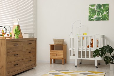 Photo of Baby's room with crib and toys. Interior design