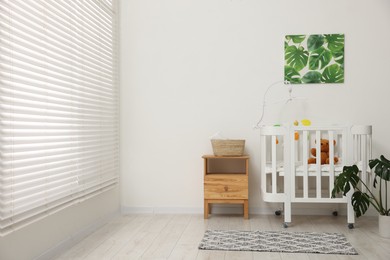 Photo of Baby's room with crib and toys. Interior design