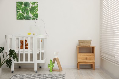 Photo of Baby's room with crib and toys. Interior design