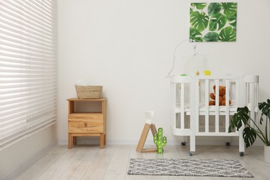 Photo of Baby's room with crib and toys. Interior design
