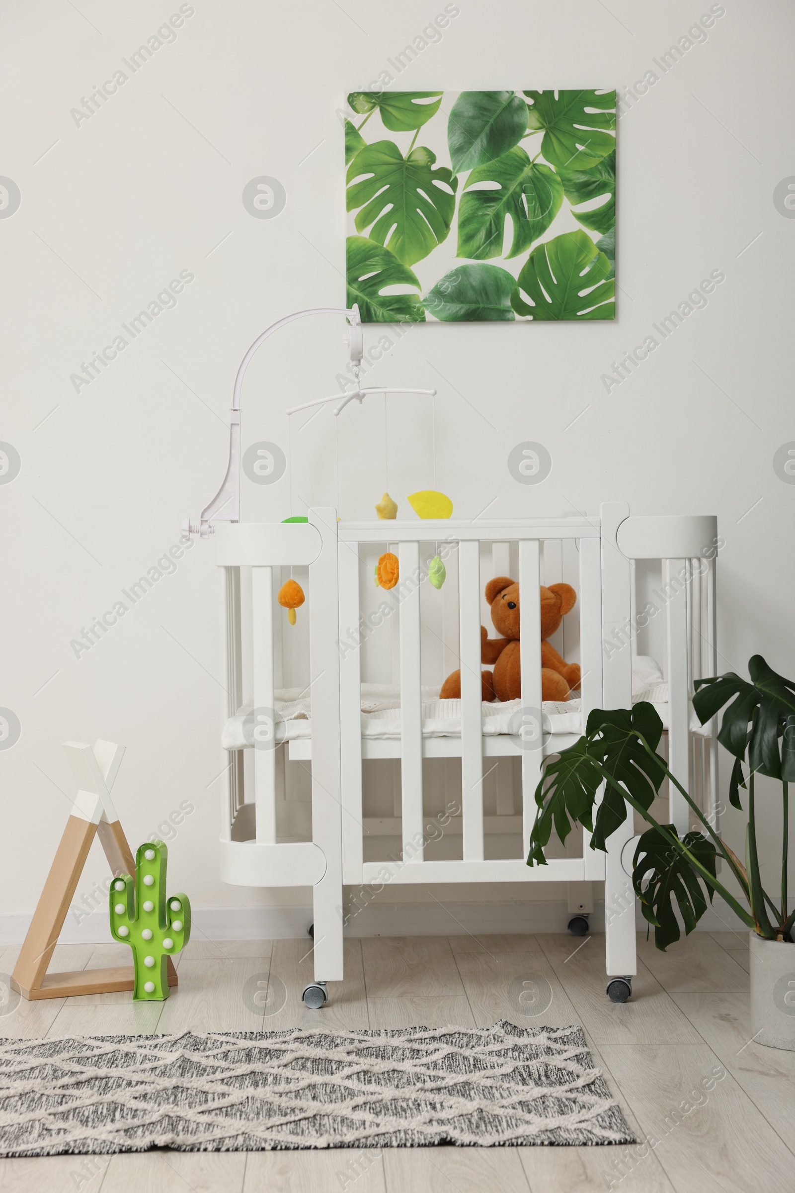 Baby's room with crib and toys. Interior design Photo of Baby's room with crib and toys. Interior design