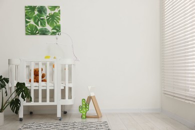 Photo of Baby's room with crib and toys. Interior design