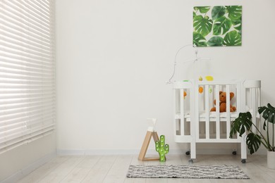 Photo of Baby's room with crib and toys. Interior design
