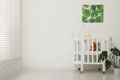Photo of Baby's room with crib and toys. Interior design