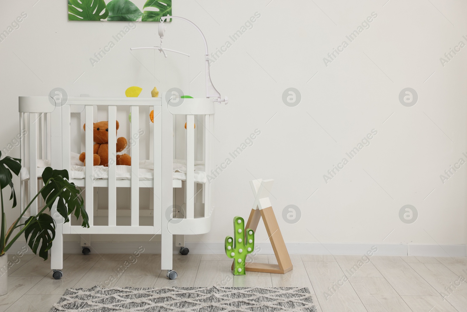 Photo of Baby's room with crib and toys. Interior design