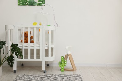 Photo of Baby's room with crib and toys. Interior design