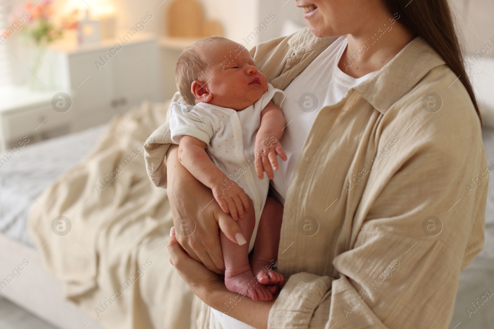 Photo of Mother with her newborn baby at home, closeup
